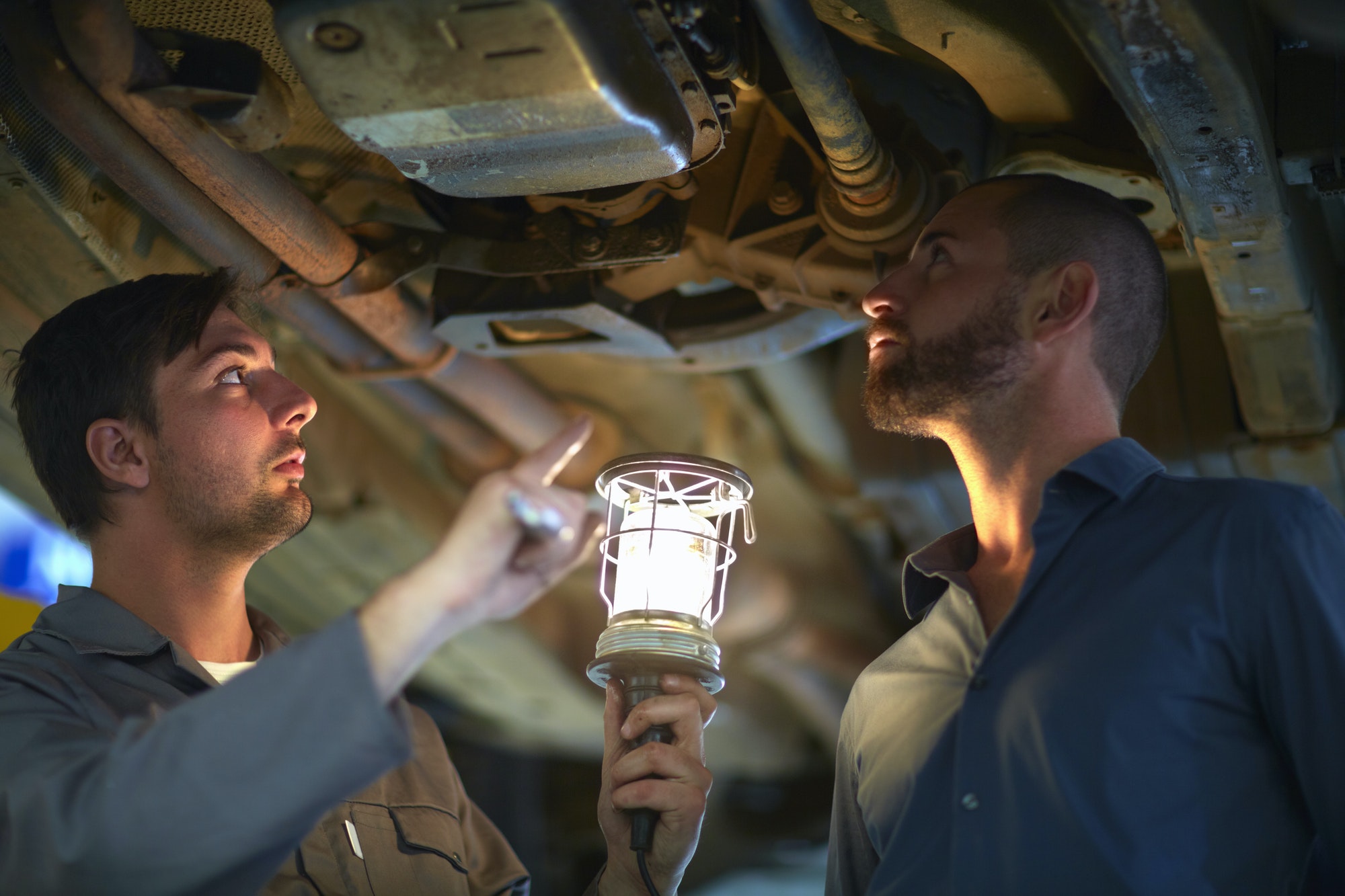 Car mechanic with client in repair garage